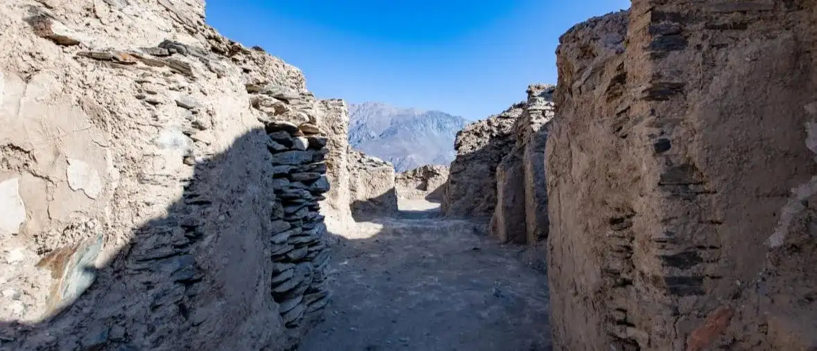 A narrow stone corridor between the ruined walls of a Pamir fortress